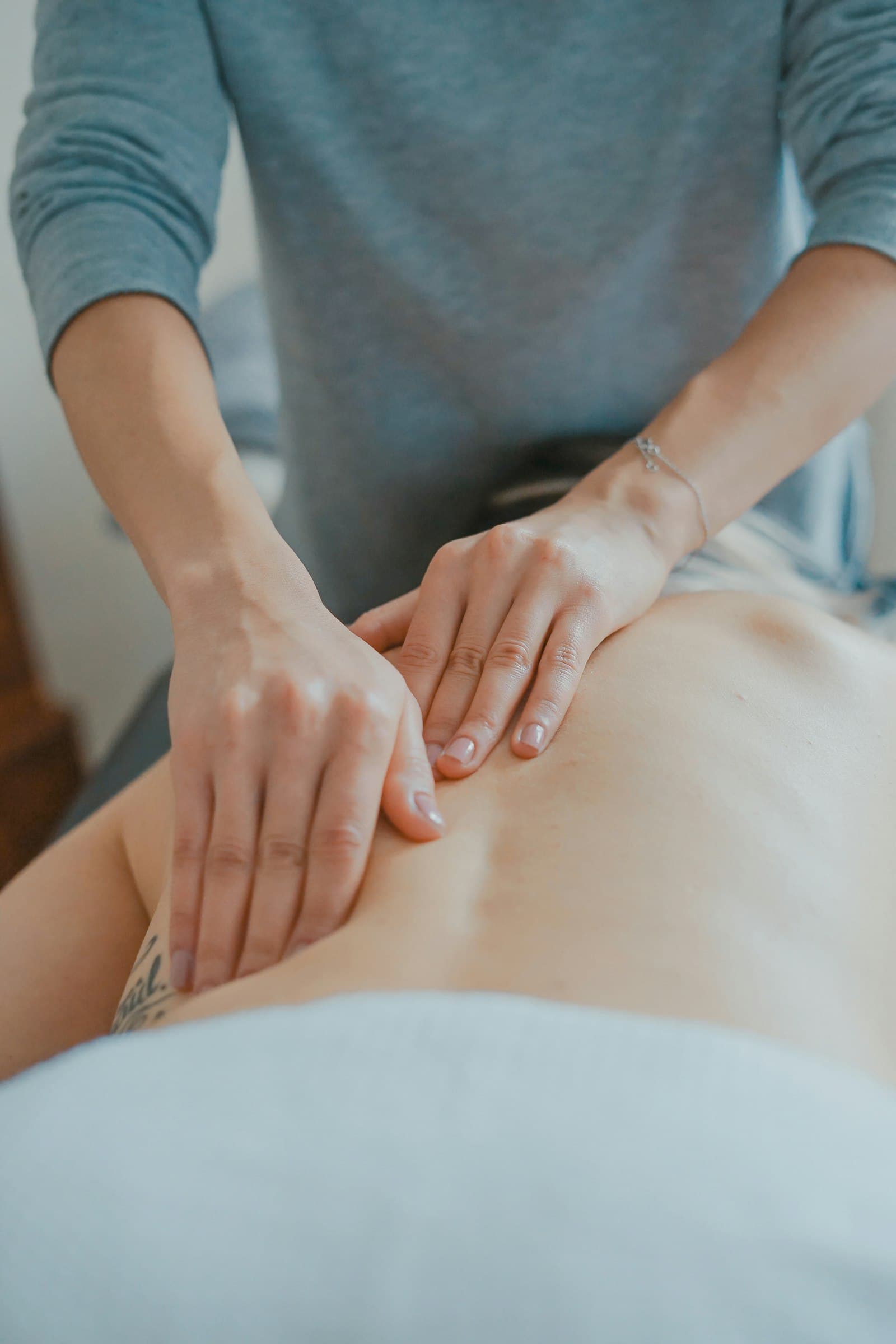 Terapeuta aplicando masaje profesional en cabina de tratamiento
